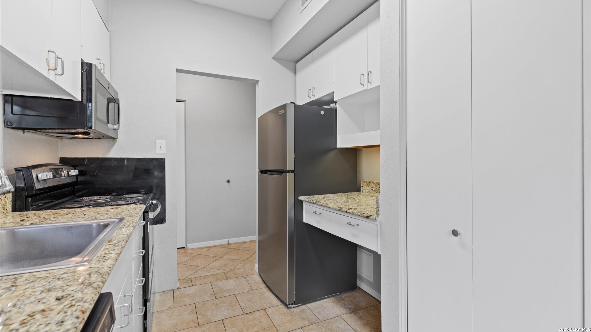8642 Fredericksburg Road, Unit 405 San Antonio, TX 78240 - Photo 5 of 24 a kitchen with stainless steel appliances a stove a refrigerator a sink a counter space and cabinets