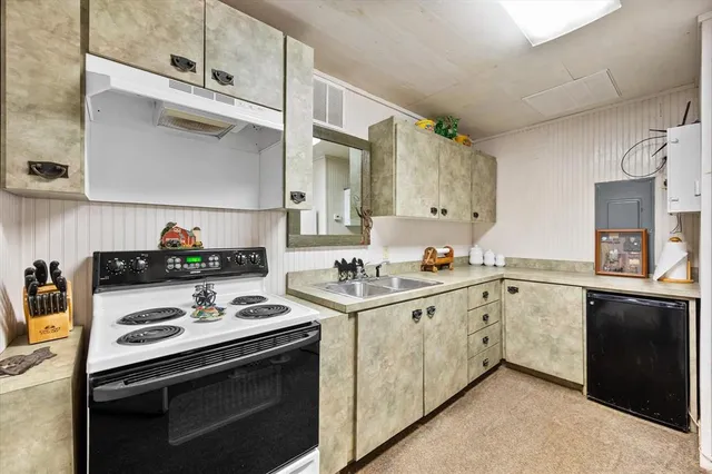 a kitchen with a stove sink and cabinets