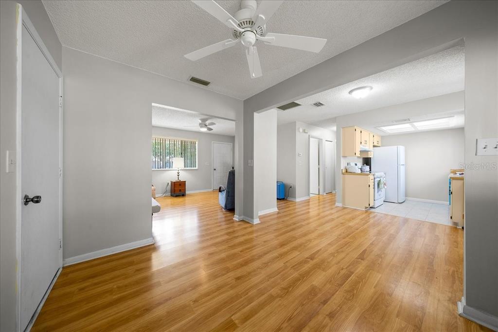 8445 Southwest 109th Street Ocala, FL 34481 - Photo 15 of 32 a big room with wooden floor and a kitchen view