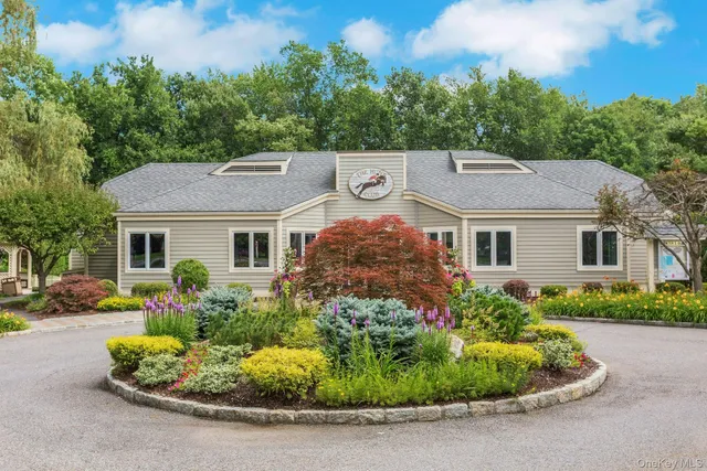 a aerial view of a house with a yard and table and chairs under an umbrella