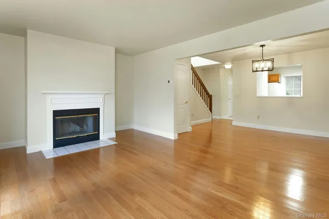 a view of empty room with wooden floor and fireplace
