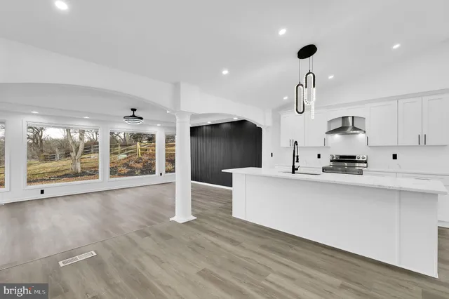 a large kitchen with stainless steel appliances a large counter top a sink a refrigerator and a granite counter tops