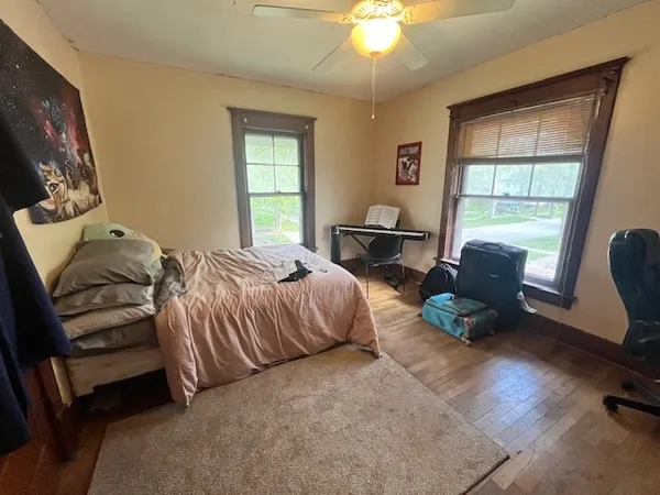 a bedroom with a bed chair and a window