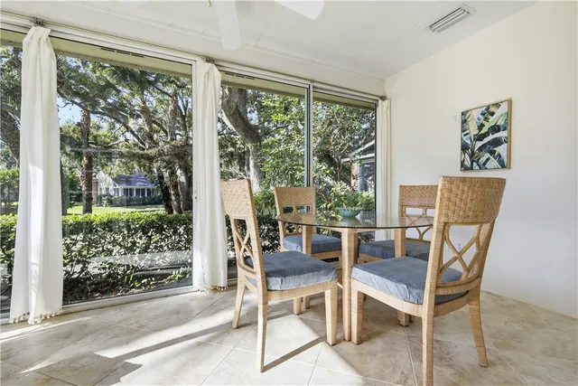 a dining room with wooden floor and glass windows