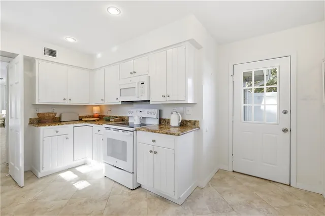 a kitchen with cabinets appliances and a window