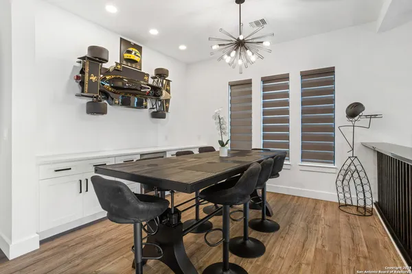 a large kitchen with sink a counter and chairs