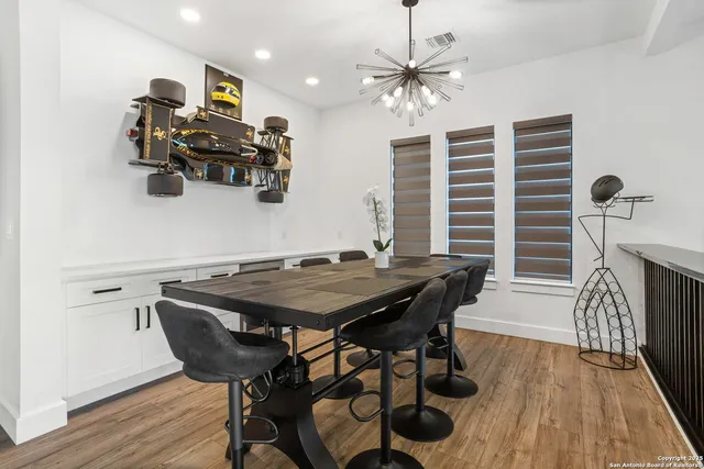 a large kitchen with sink a counter and chairs