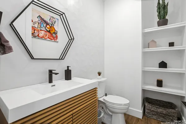 a large bedroom with a bed and wooden floor