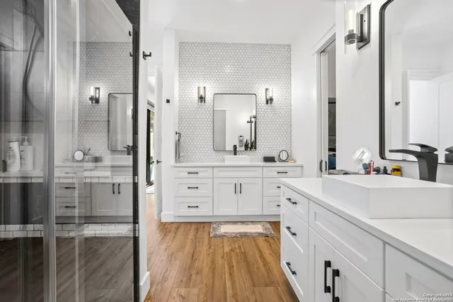 a en suite bathroom with a granite countertop sink and a mirror