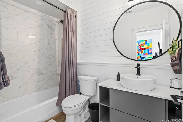 a bathroom with a sink a toilet and shower