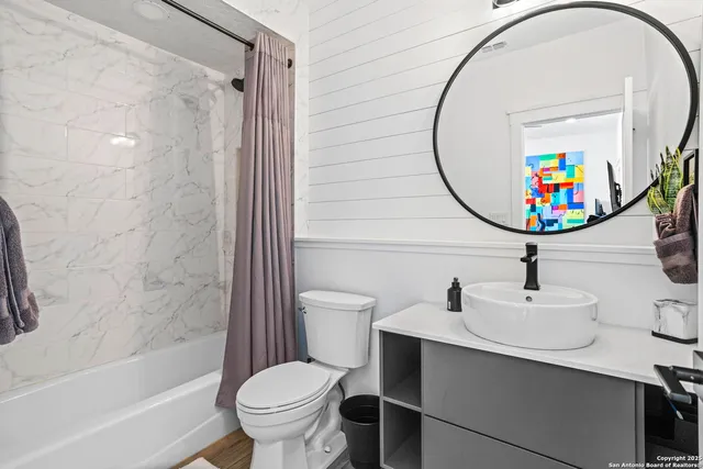 a bathroom with a sink a toilet and shower