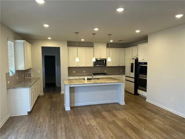 a large kitchen with stainless steel appliances granite countertop a stove and a refrigerator