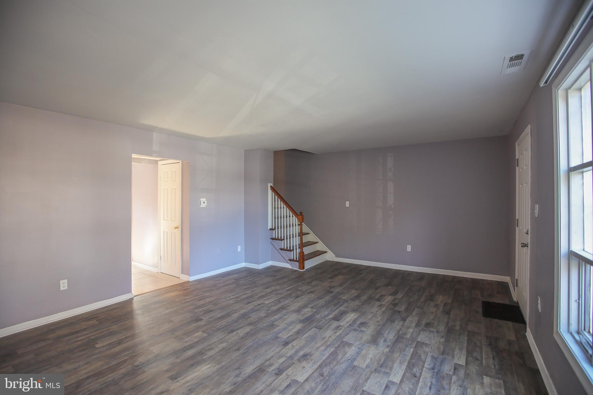 1705 Addison Road South District Heights, MD 20747 - Photo 1 of 26 a view of an empty room with wooden floor and stairs