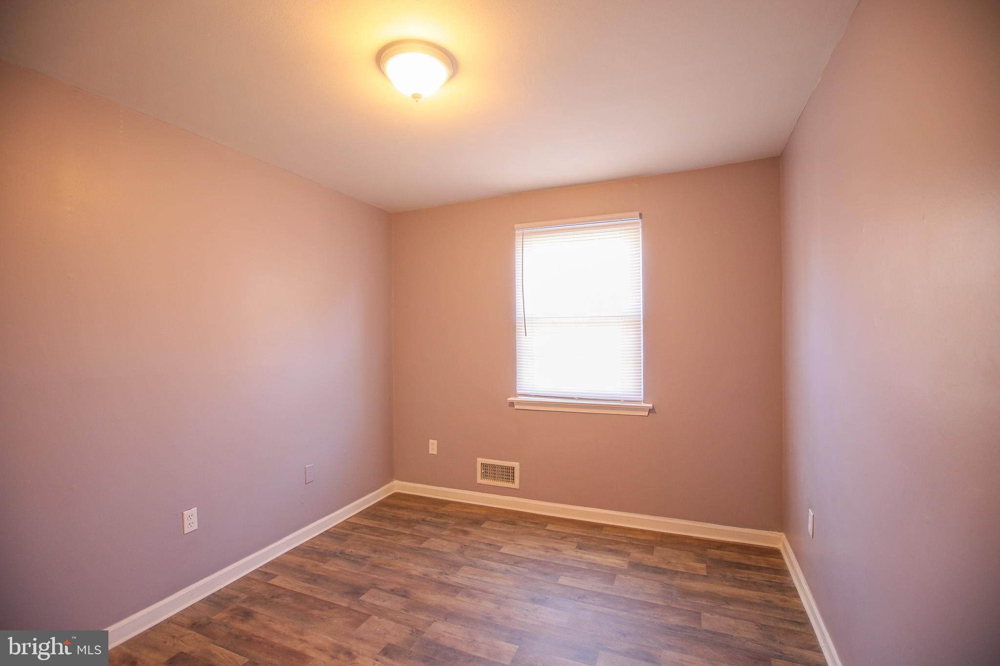 1705 Addison Road South District Heights, MD 20747 - Photo 16 of 26 an empty room with wooden floor and windows