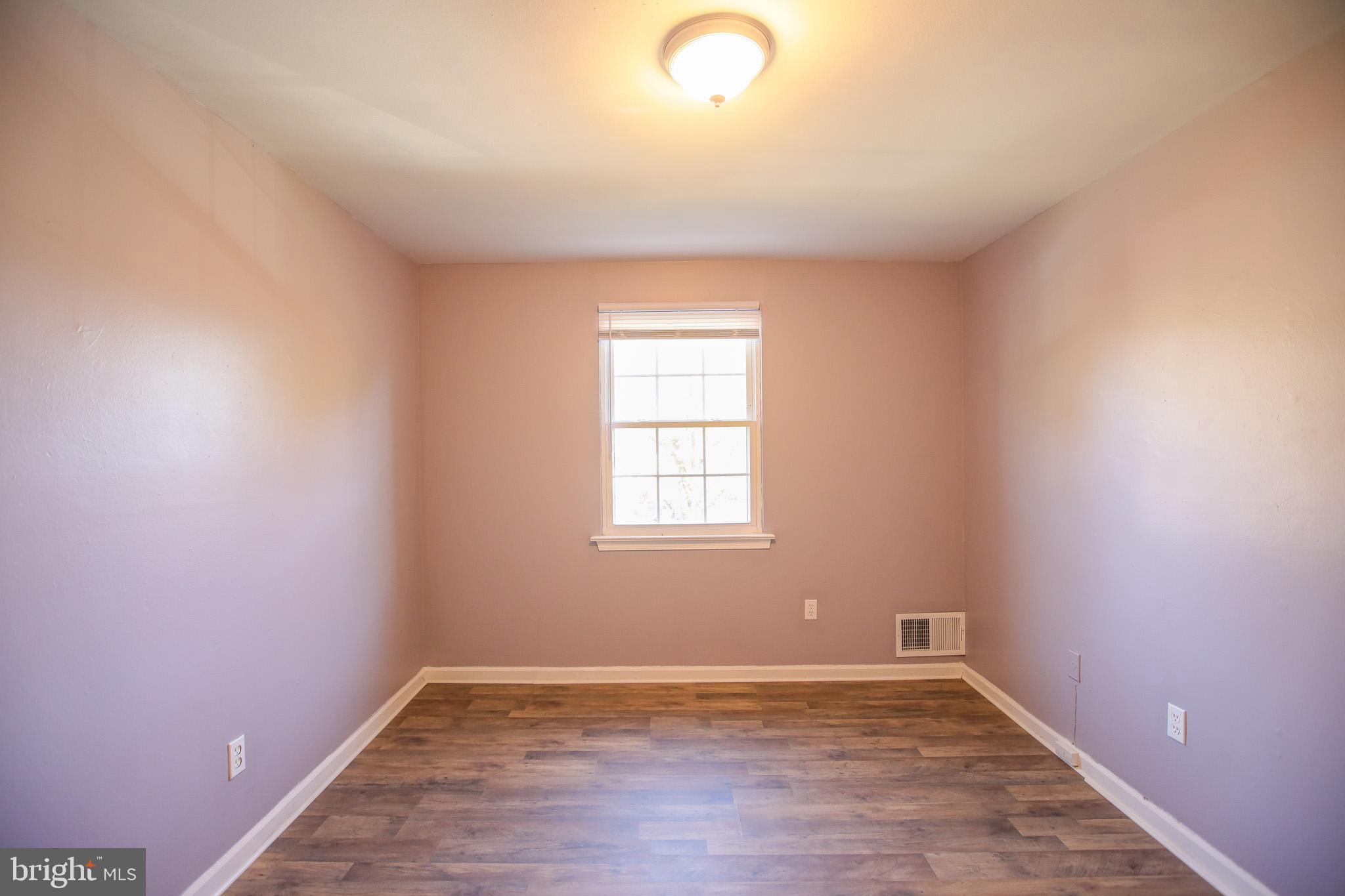 1705 Addison Road South District Heights, MD 20747 - Photo 19 of 26 an empty room with wooden floor and windows