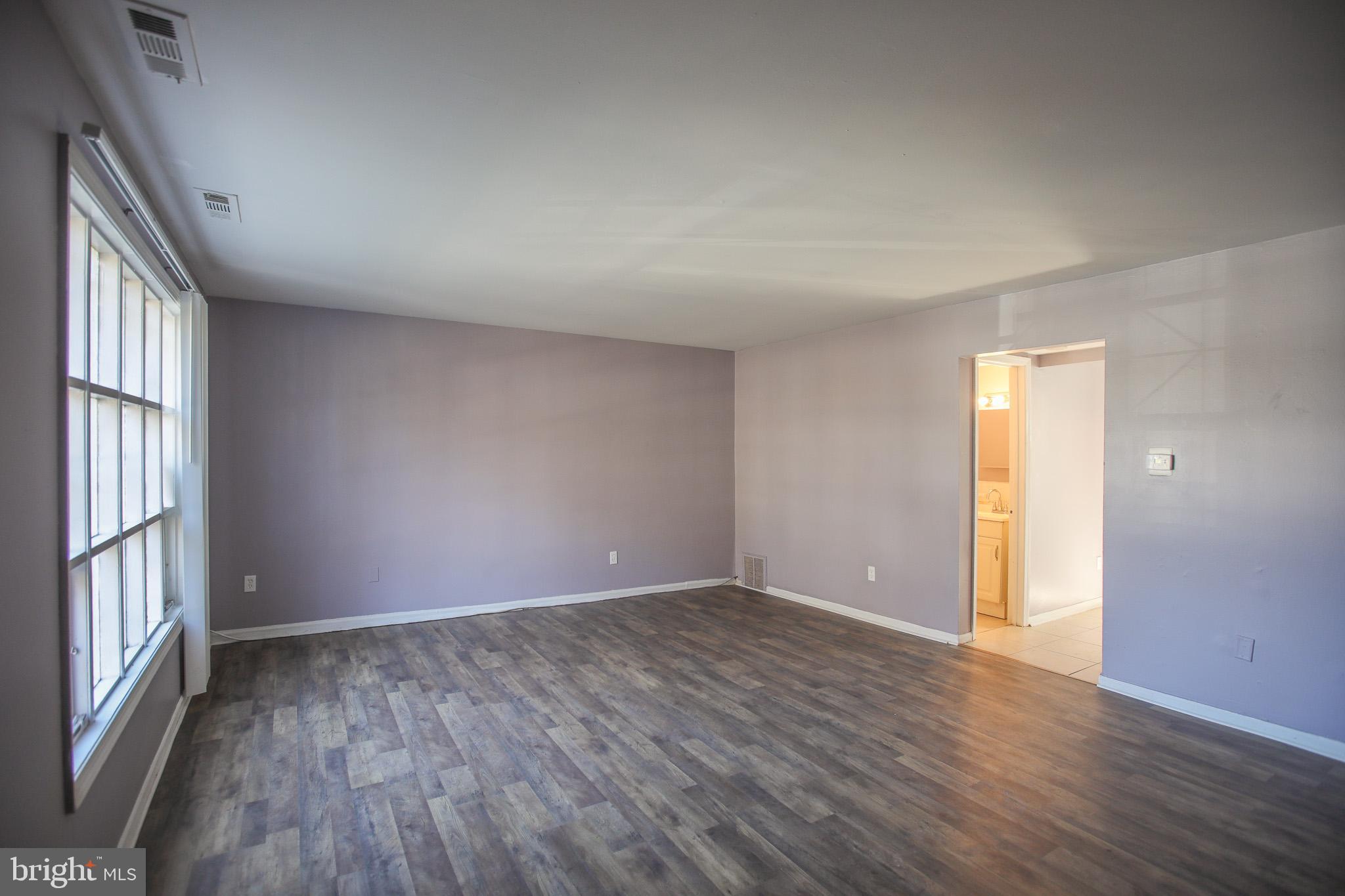 1705 Addison Road South District Heights, MD 20747 - Photo 5 of 26 an empty room with wooden floor and windows