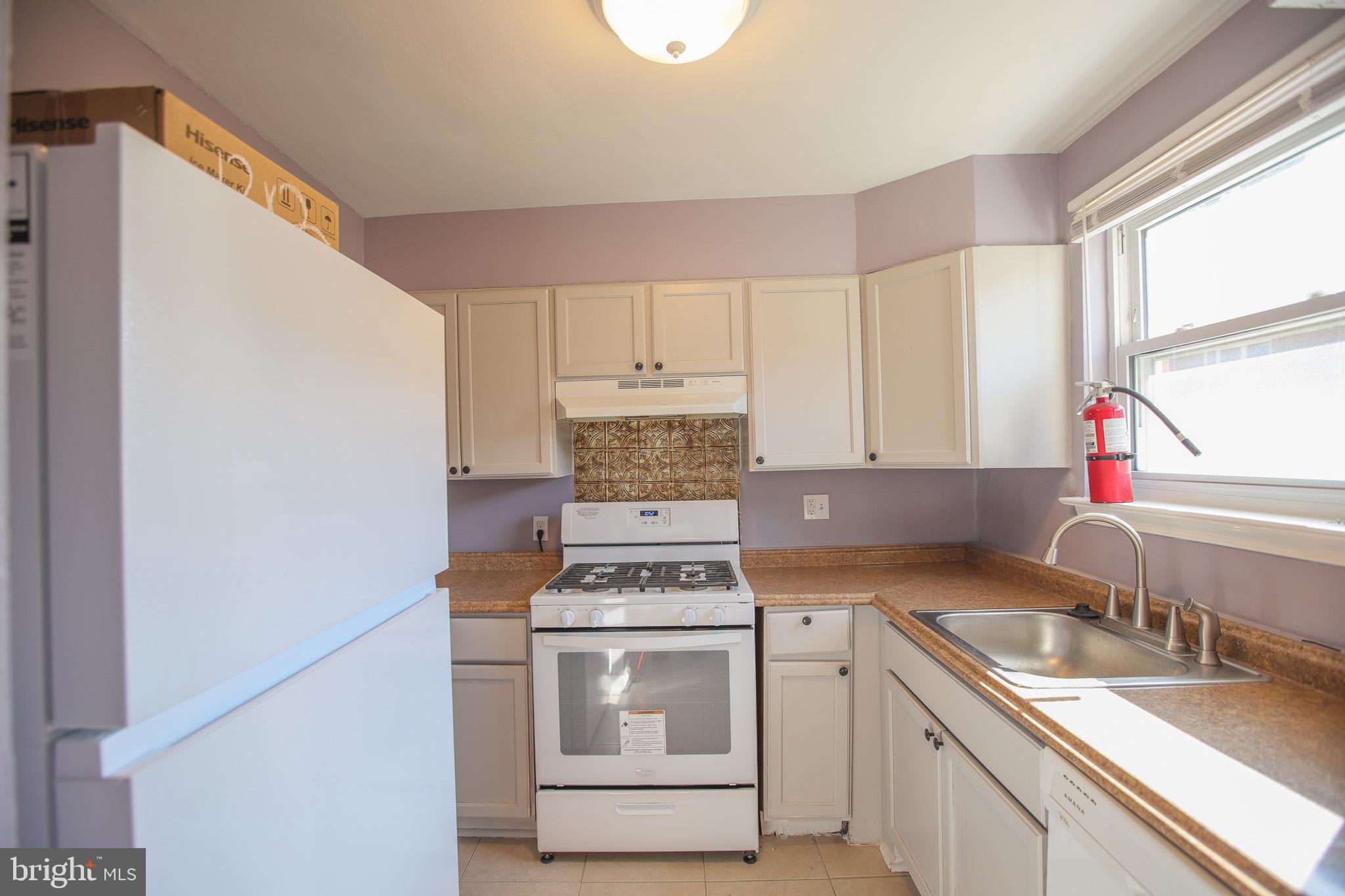 1705 Addison Road South District Heights, MD 20747 - Photo 8 of 26 a kitchen with a stove a sink and a microwave