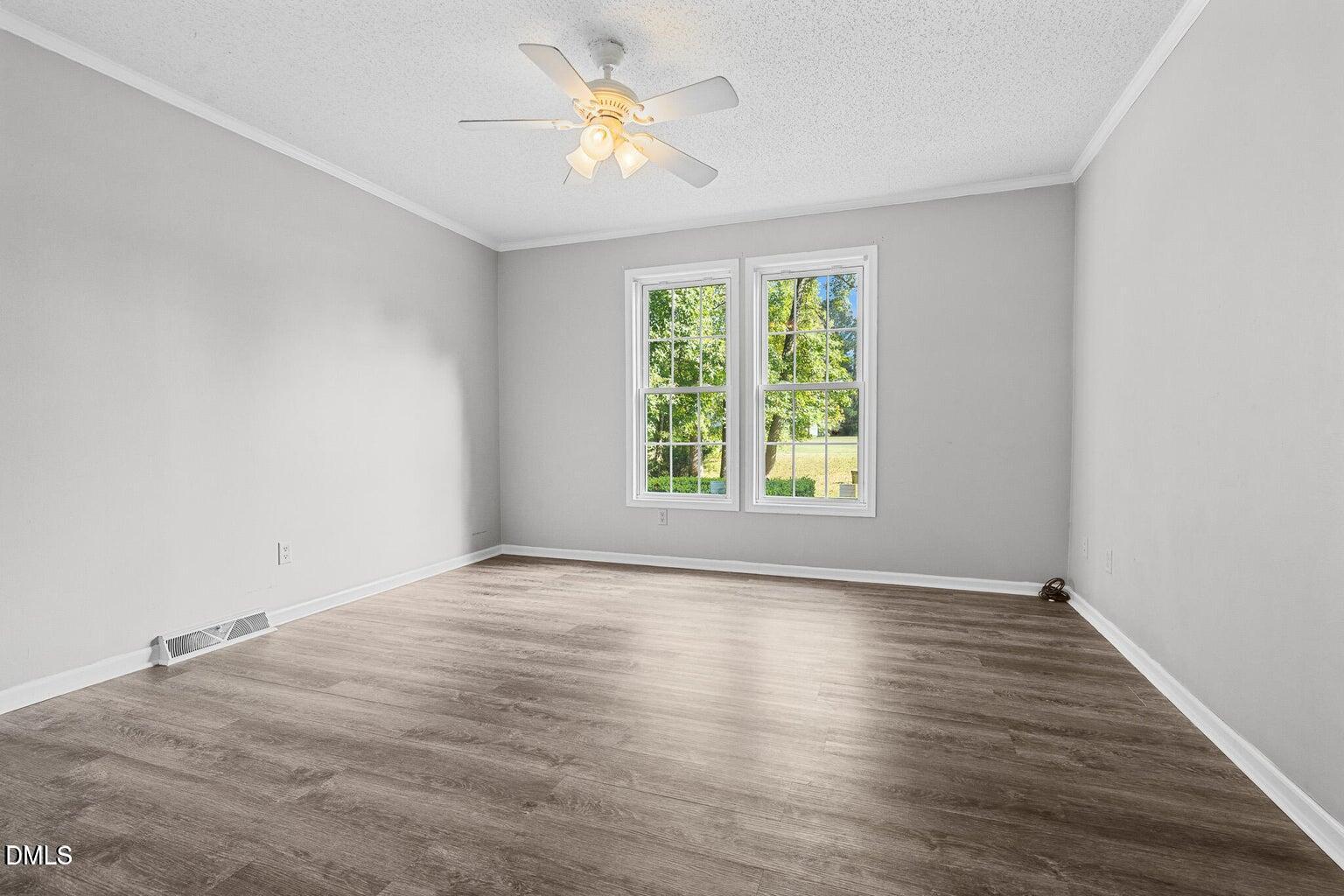 4551 Sugar Maple Road Oxford, NC 27565 - Photo 20 of 23 an empty room with wooden floor chandelier fan and windows