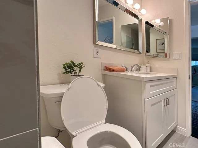 a bathroom with a toilet a sink and mirror