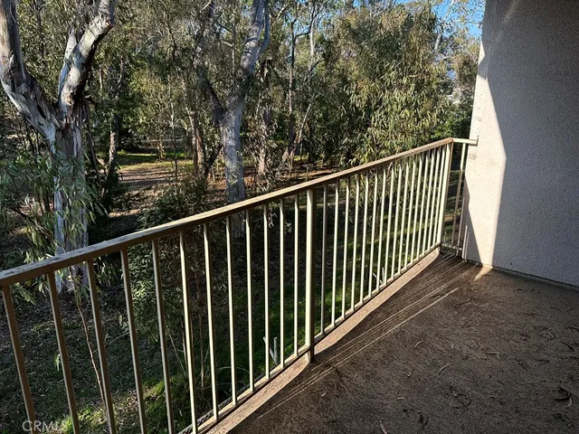 a view of a balcony with wooden floor and fence