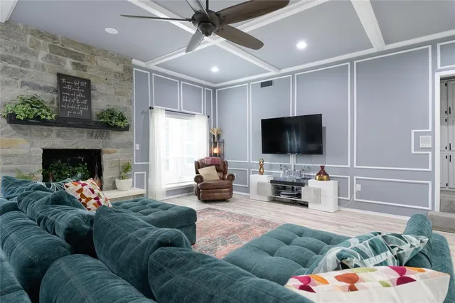 a living room with furniture a flat screen tv and a fireplace