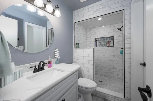 a bathroom with a sink a toilet and shower