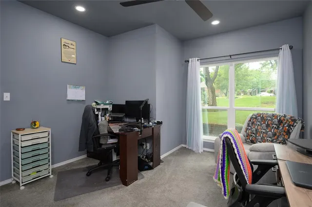 a view of a workspace with furniture and a window