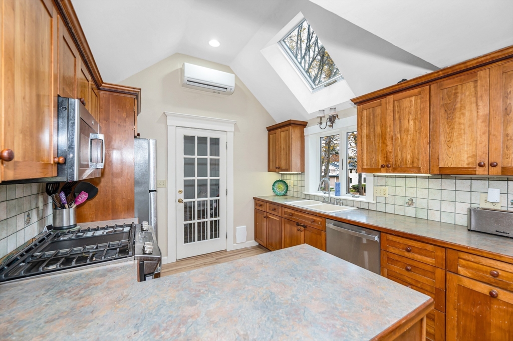 856 Main Street Reading, MA 01867 - Photo 11 of 41 a large kitchen with stainless steel appliances granite countertop a sink and cabinets