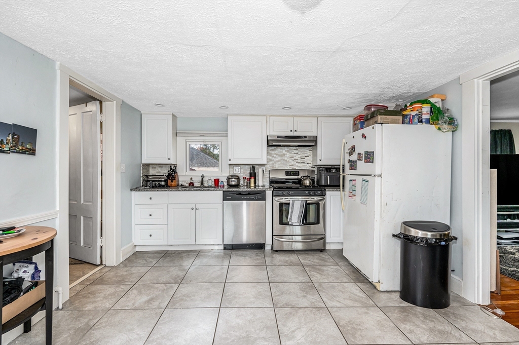 856 Main Street Reading, MA 01867 - Photo 22 of 41 a kitchen with a refrigerator and white cabinets