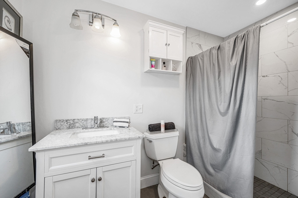 856 Main Street Reading, MA 01867 - Photo 26 of 41 a bathroom with a granite countertop toilet sink and shower