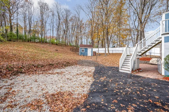 a backyard of a house with a table and chairs and potted plants
