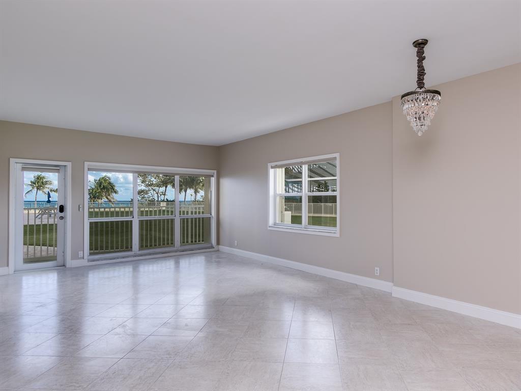 750 North Ocean Boulevard, Unit 210 Pompano Beach, FL 33062 - Photo 5 of 57 an empty room with floor to ceiling windows and carpet