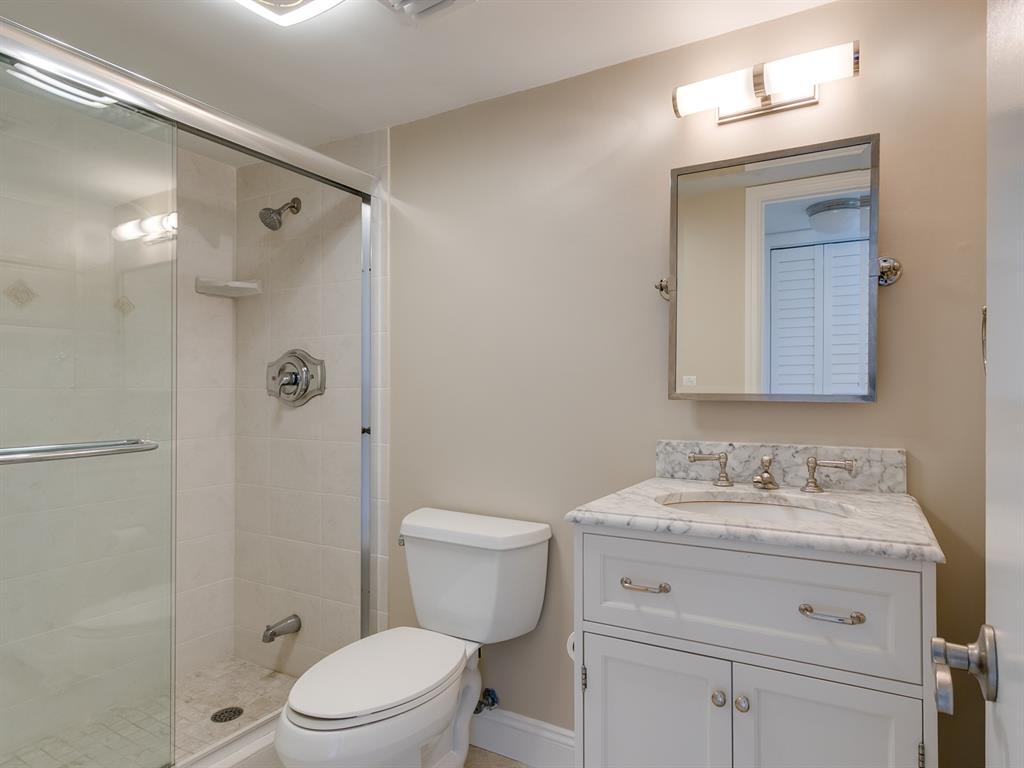 750 North Ocean Boulevard, Unit 210 Pompano Beach, FL 33062 - Photo 7 of 57 a bathroom with a granite countertop sink toilet a mirror a vanity and shower
