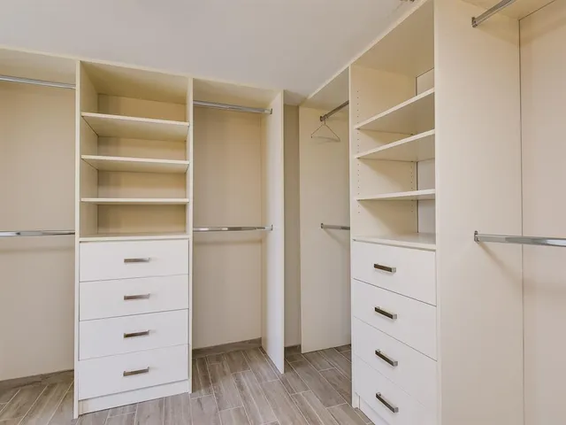 a view of walk in closet with empty racks