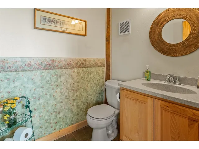 a bathroom with a granite countertop toilet sink and mirror