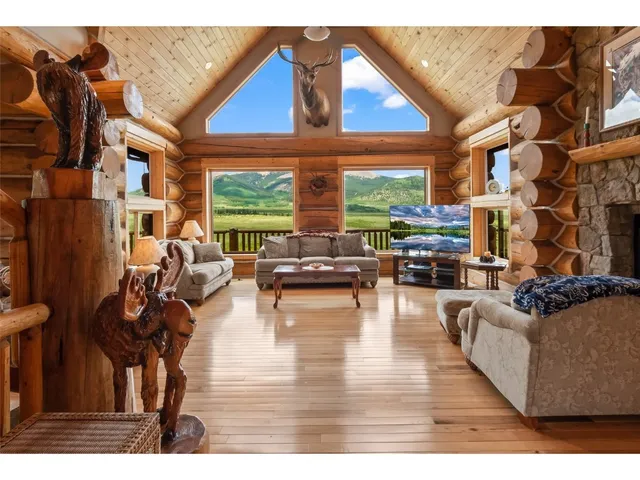 a living room with fireplace furniture and a large window