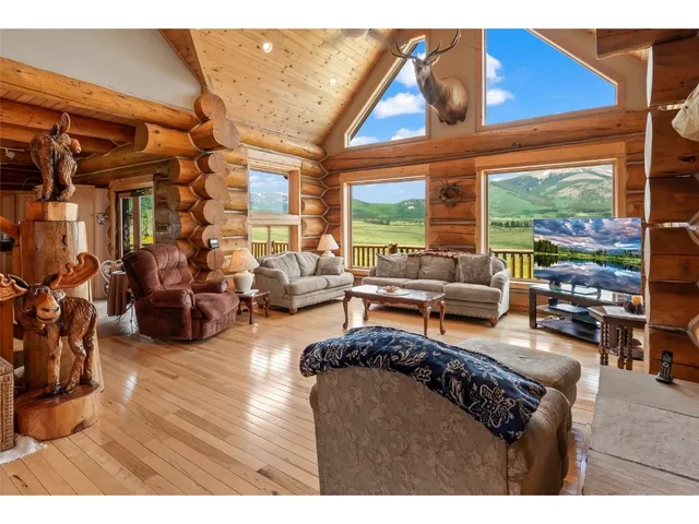 a living room with furniture a rug and a large window