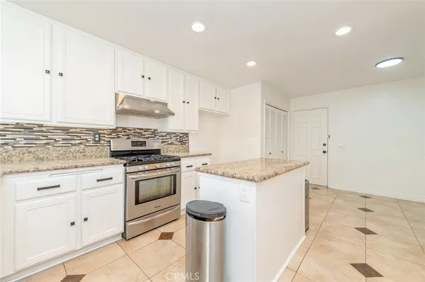 a kitchen with granite countertop cabinets stainless steel appliances and a counter space