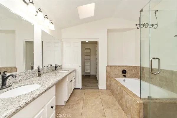 a spacious bathroom with a granite countertop sink mirror and bathtub