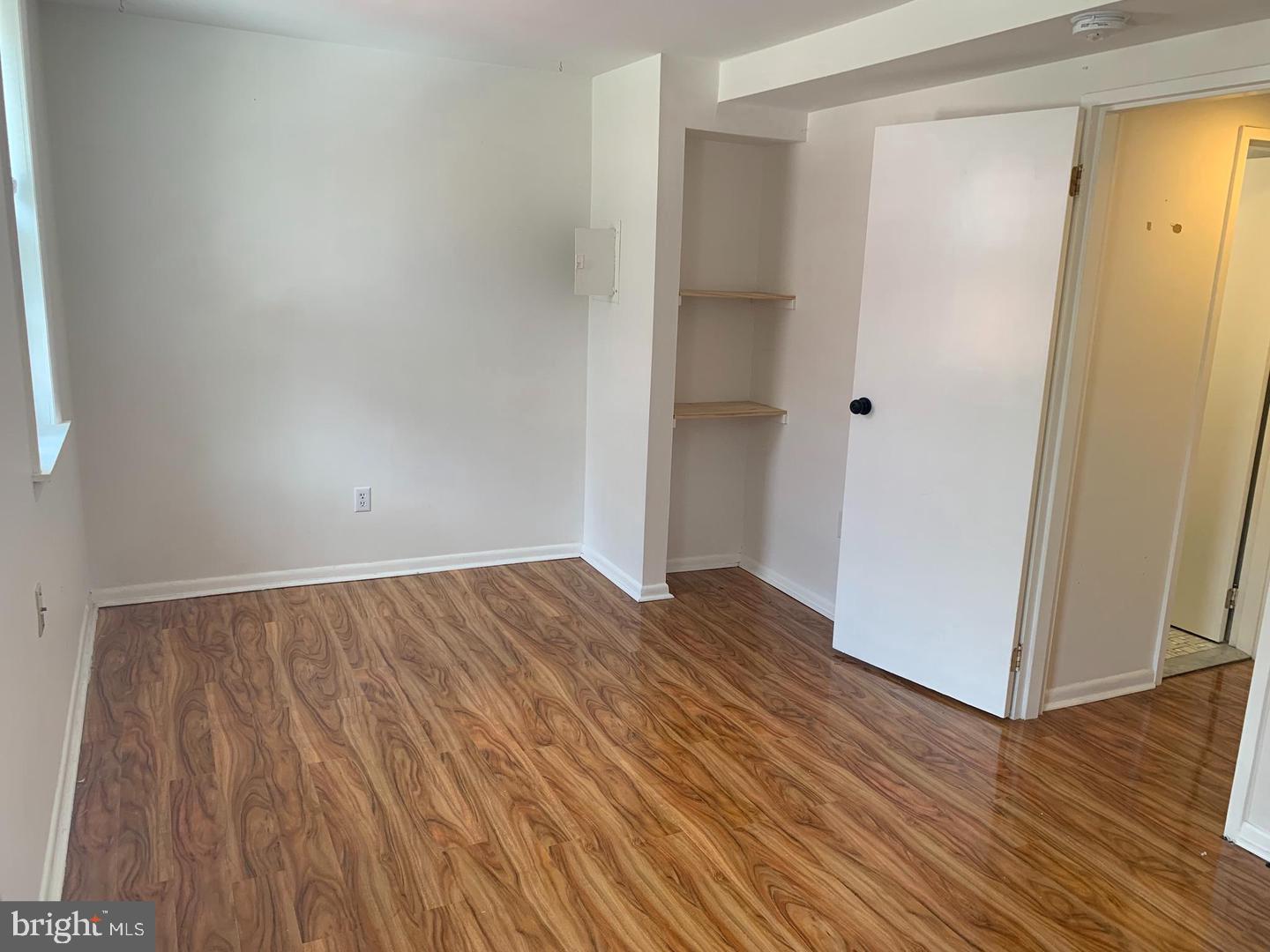 1018 Pine Street, Unit 2F Philadelphia, PA 19107 - Photo 2 of 12 a view of an empty room with wooden floor and a window