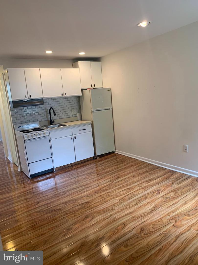 1018 Pine Street, Unit 2F Philadelphia, PA 19107 - Photo 4 of 12 a kitchen with kitchen island sink and wooden floor