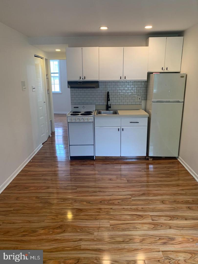 1018 Pine Street, Unit 2F Philadelphia, PA 19107 - Photo 5 of 12 a kitchen with stainless steel appliances granite countertop a refrigerator a stove and a wooden floors