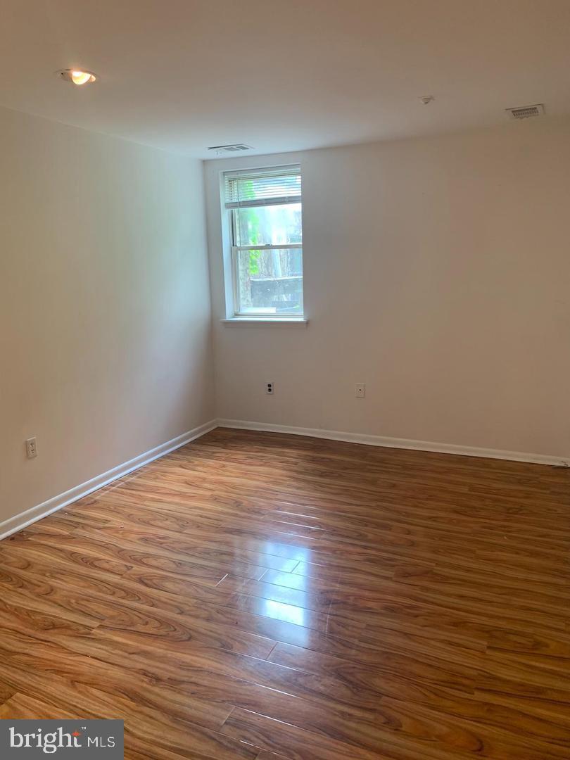 1018 Pine Street, Unit 2F Philadelphia, PA 19107 - Photo 7 of 12 an empty room with wooden floor and windows
