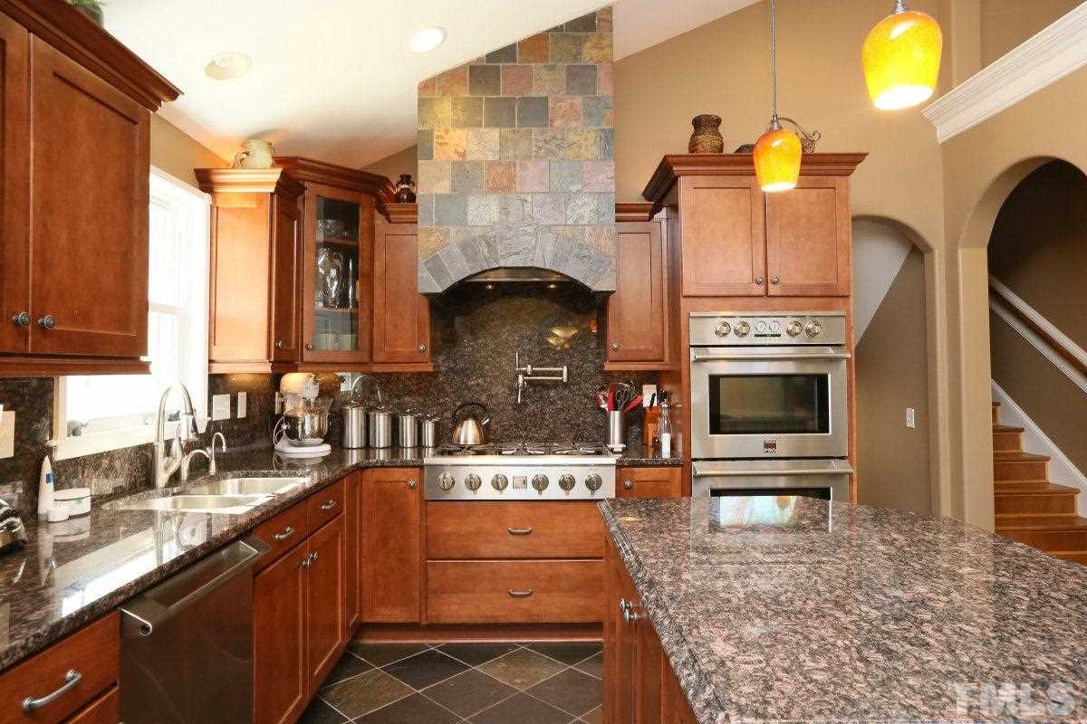 8517 Shadow Wood Place Raleigh, NC 27613 - Photo 14 of 25 a kitchen with stainless steel appliances granite countertop a stove and a sink