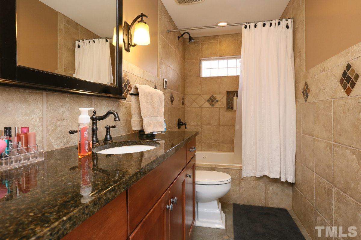 8517 Shadow Wood Place Raleigh, NC 27613 - Photo 18 of 25 a bathroom with a sink a toilet and shower