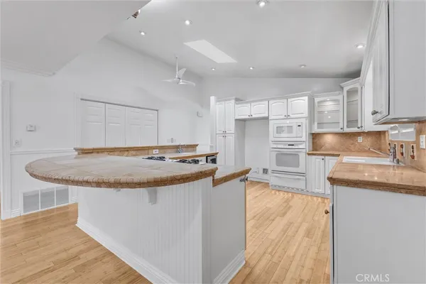 a kitchen with stainless steel appliances kitchen island granite countertop a refrigerator and a stove top oven