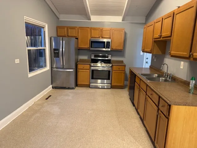 a kitchen with stainless steel appliances granite countertop a stove a sink and a refrigerator