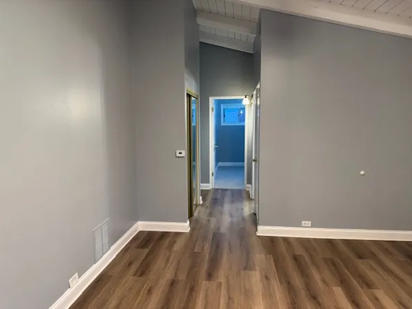 a view of empty room with wooden floor