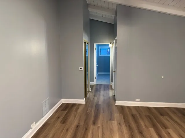 a view of empty room with wooden floor