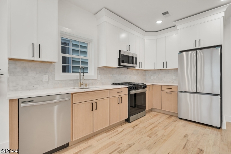 196 Taylor Street Orange, NJ 07050 - Photo 1 of 31 a kitchen with cabinets stainless steel appliances a sink and a window